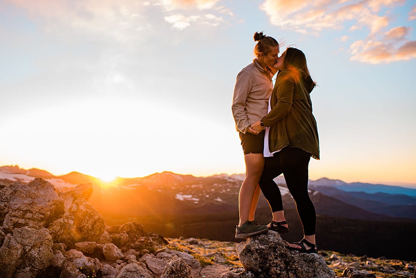 brides kiss at sunset at Rocky Mountain National Park engagement session by Colorado Gay Wedding photographer Jennie Crate