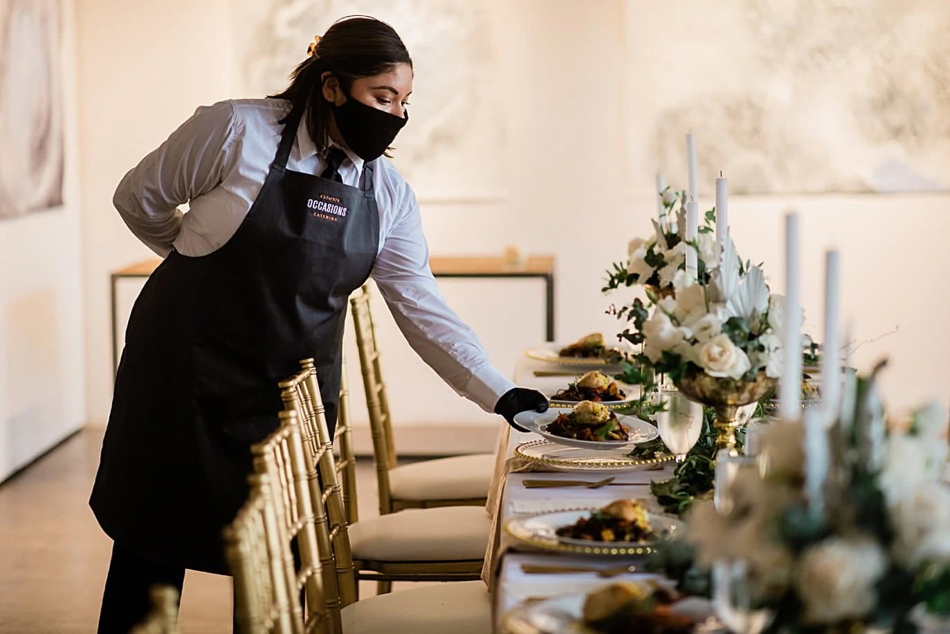 caterer serving meal at table wearing mask at Walker Fine Art Gallery Wedding by Boulder Wedding Photographer Jennie Crate