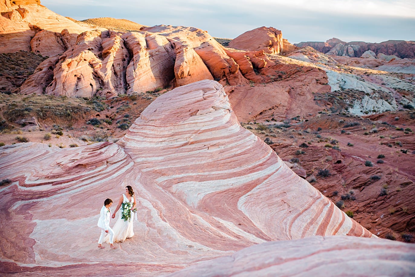 two brides walk at sunset in Valley of Fire Nevada at Valley of Fire wedding by Las Vegas wedding photographer Jennie Crate