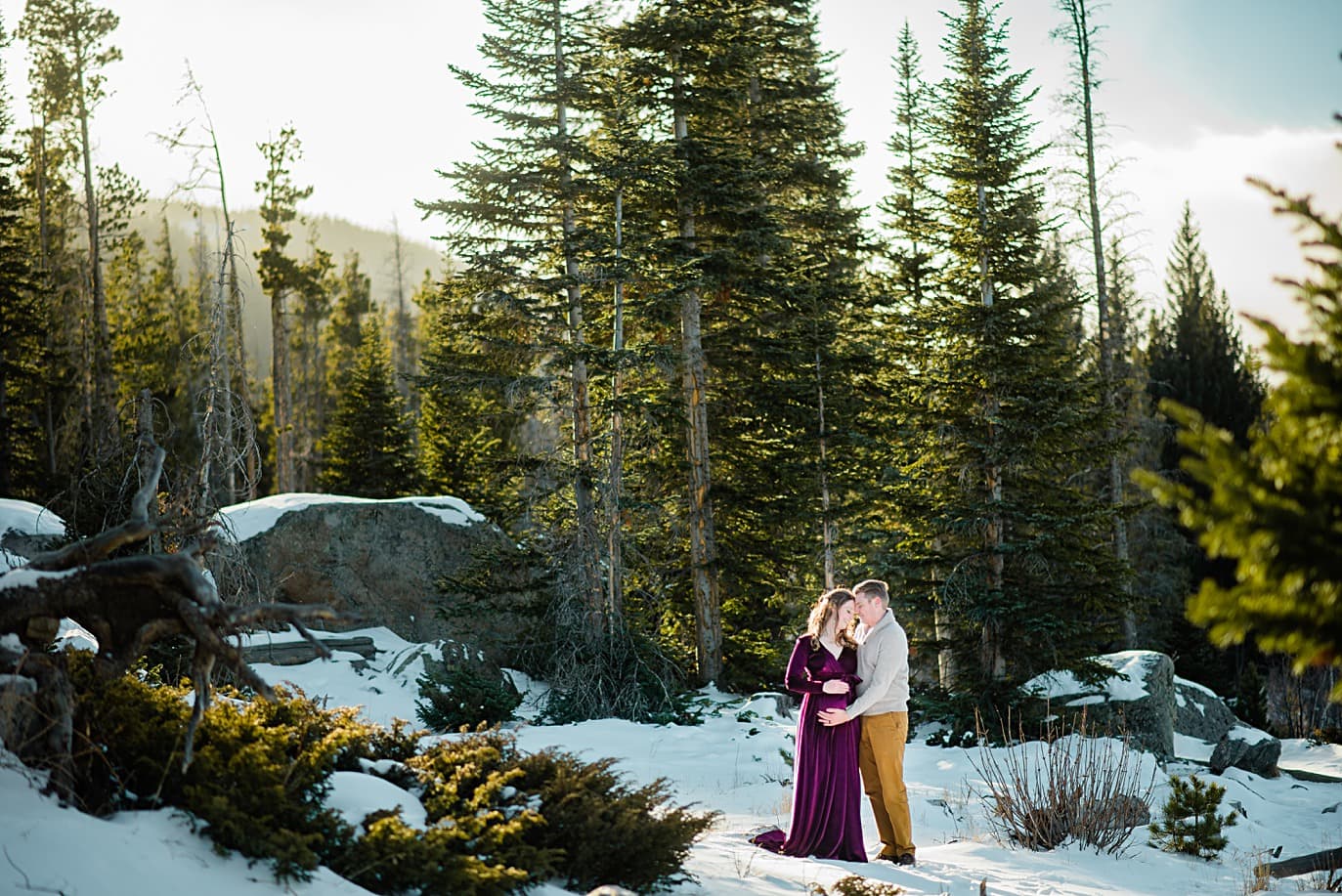 couple in forest in winter for maternity session