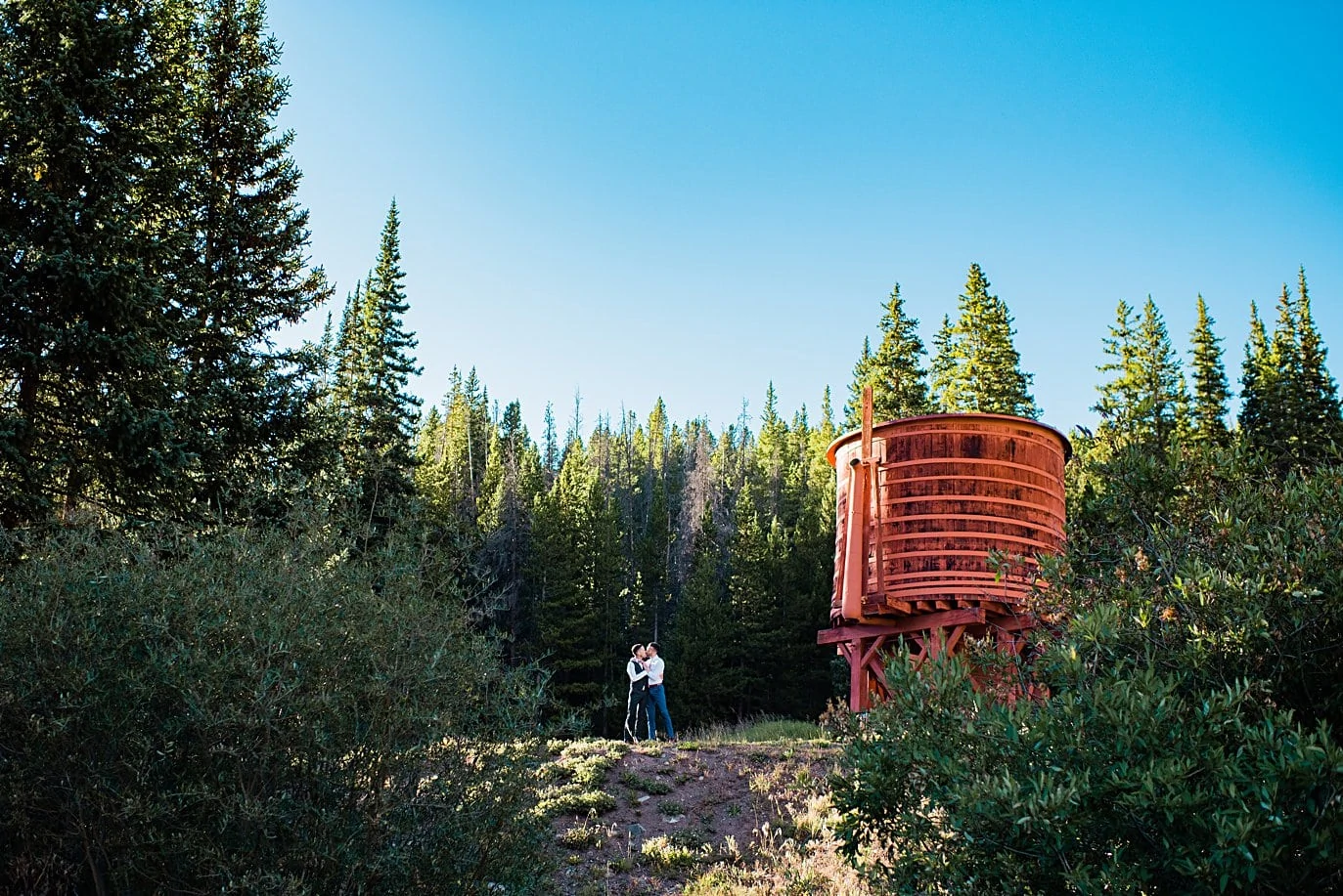 grooms by water tower before ceremony at Breckenridge Elopement by Colorado gay wedding photographer Jennie Crate