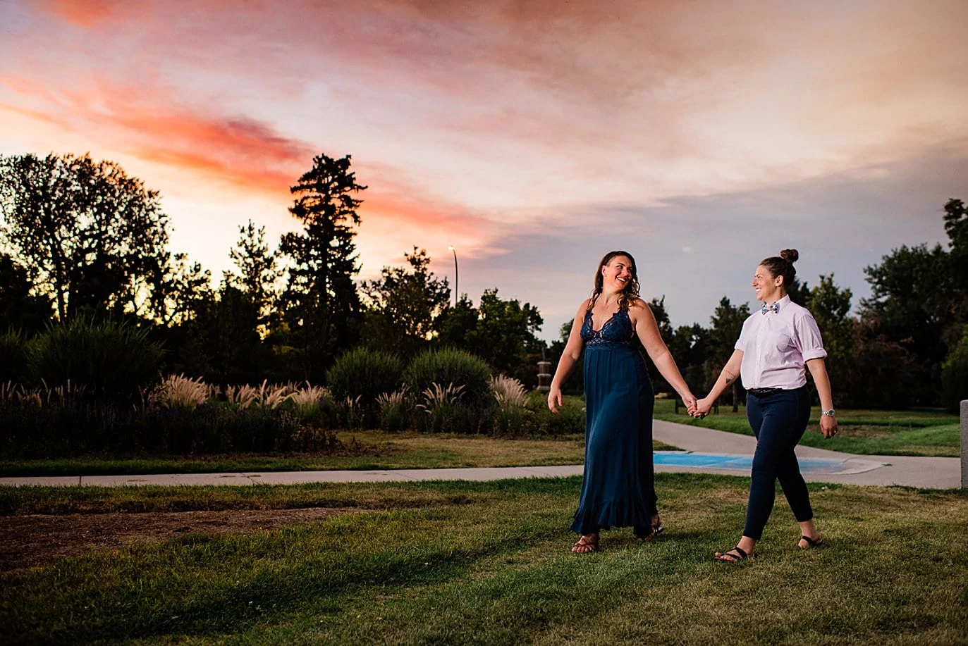 two brides walk hand in hand at sunset after proposal in City Park Denver by Denver proposal photographer Jennie Crate