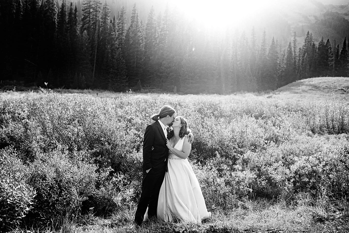 bride and groom at sunset with evergreen trees at Crested Butte elopement by Denver wedding photographer Jennie Crate