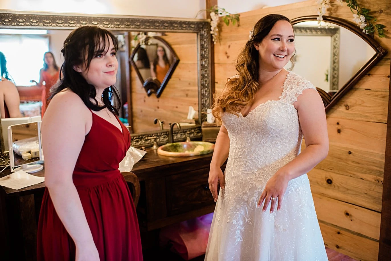 bride and sister getting ready in barn at Deer Creek Valley Ranch wedding by Conifer wedding photographer Jennie Crate