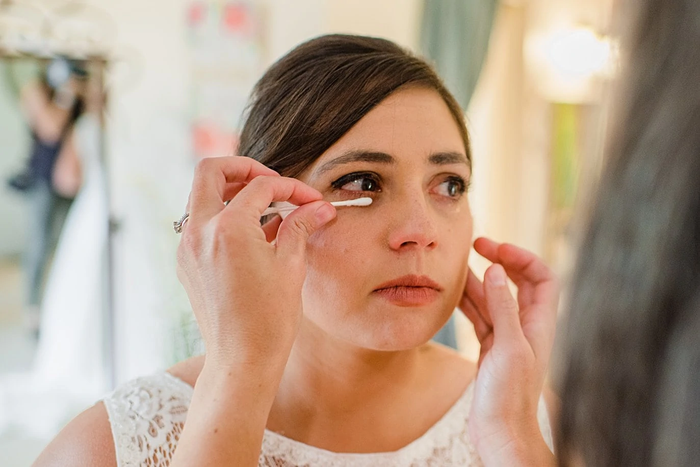 bridesmaid wipes away tears of bride during getting ready at Deer Creek Valley Ranch wedding by Conifer wedding photographer Jennie Crate