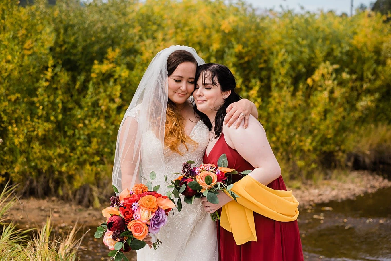 bride hugs sister at Deer Creek Valley Ranch wedding by Denver wedding photographer Jennie Crate