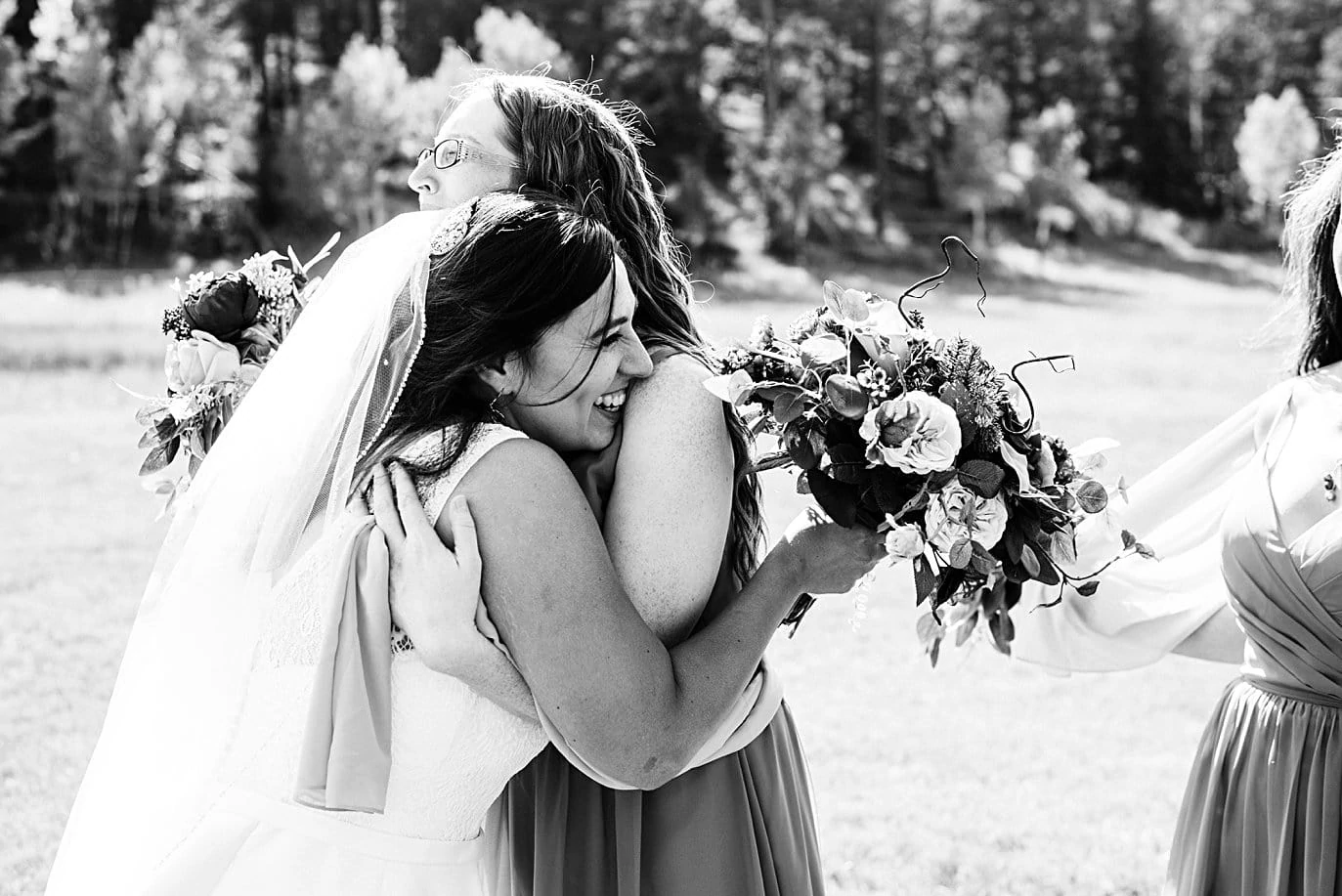 bride hugs friends at fall Deer Creek Valley Ranch wedding by Denver wedding photographer Jennie Crate