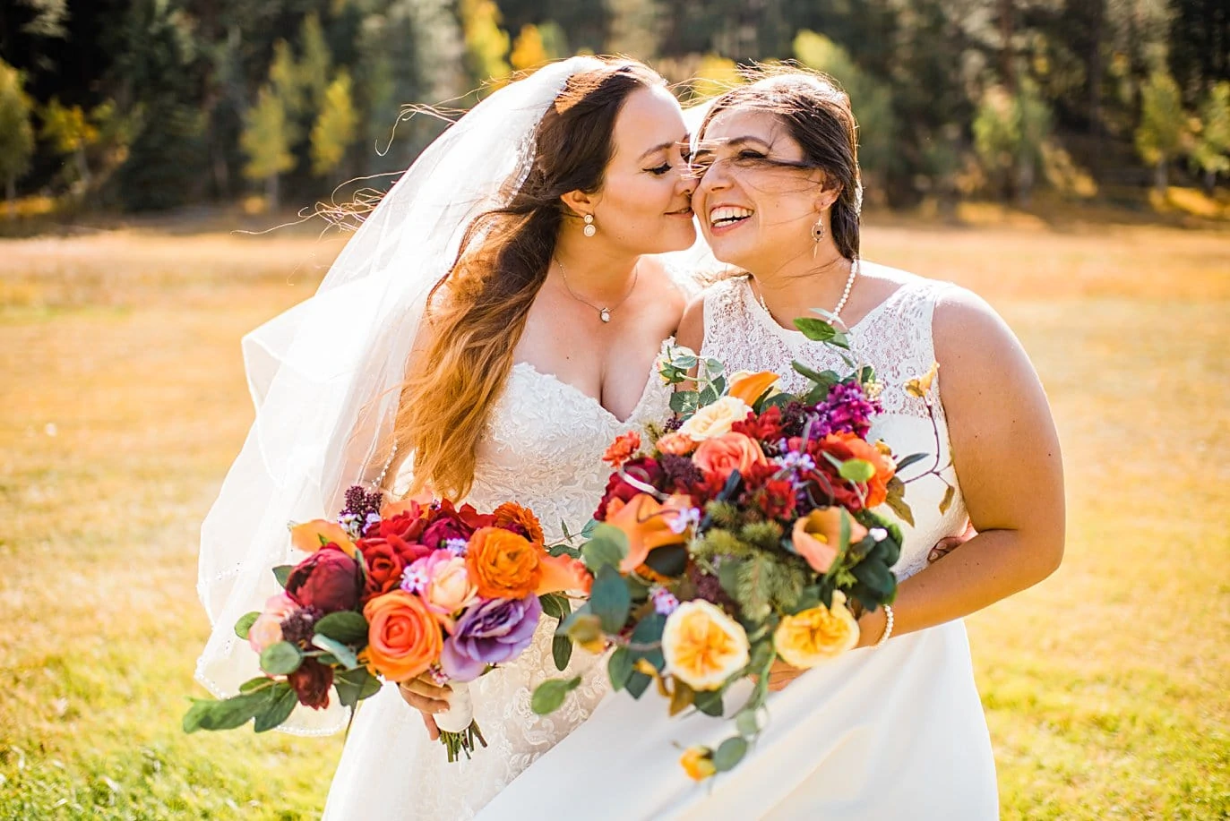 two brides cuddle before ceremony at fall Deer Creek Valley Ranch wedding by Denver wedding photographer Jennie Crate