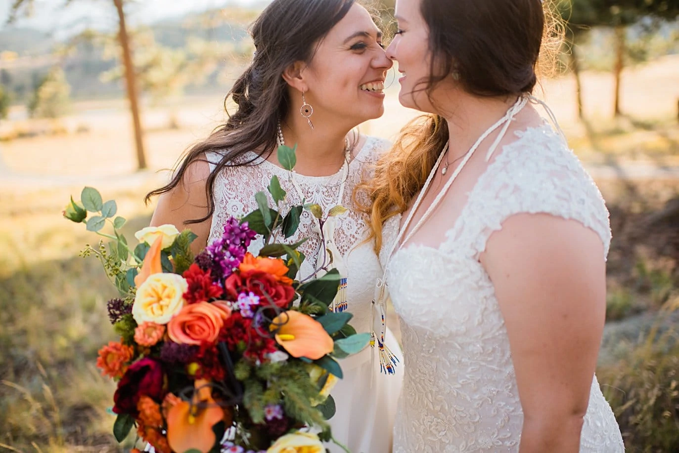two brides cuddle after wedding ceremony at Deer Creek Valley Ranch same-sex wedding by Denver LGBT wedding photographer Jennie Crate