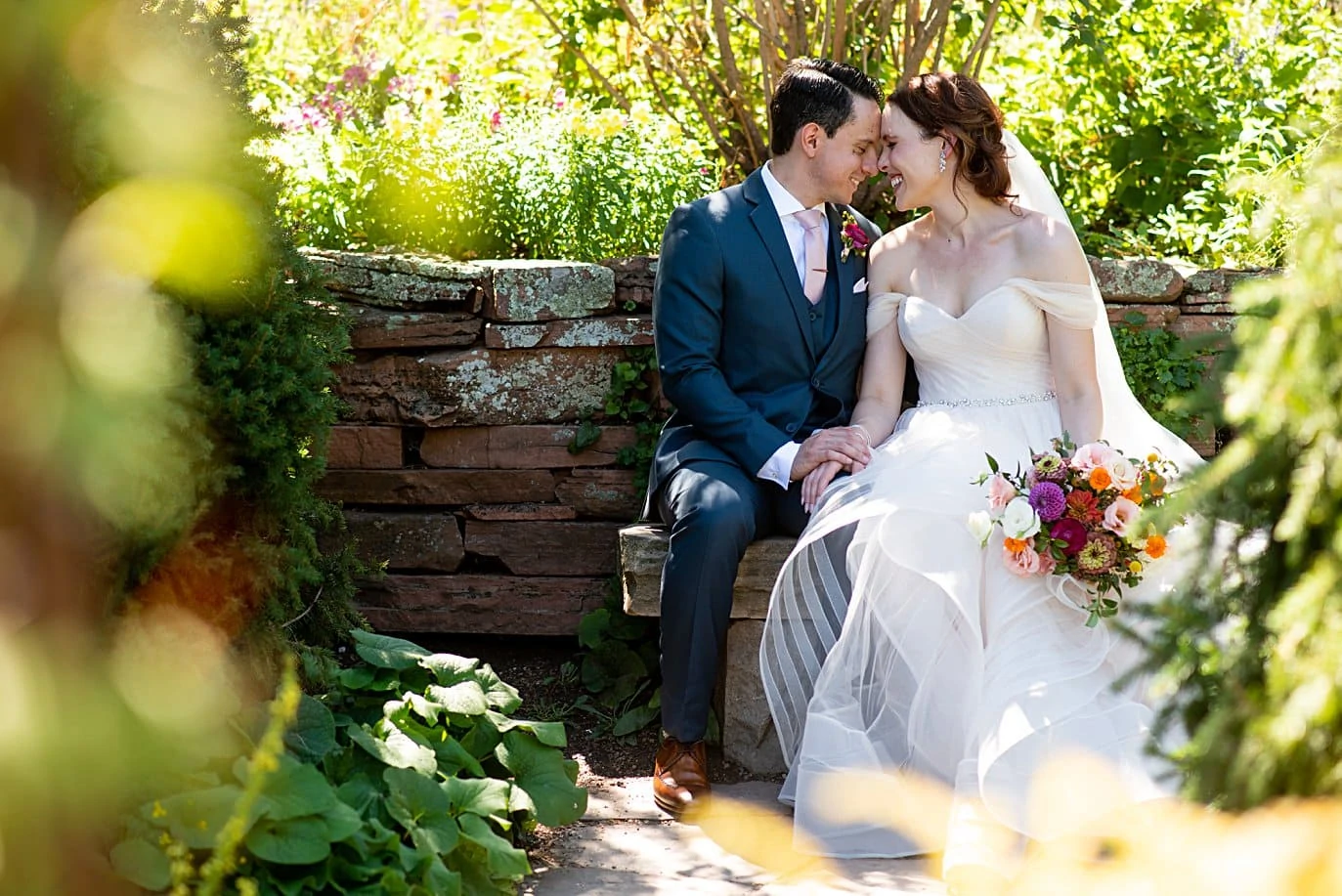bride and groom find hidden stone bench at Denver Botanic Gardens microwedding by Boulder wedding photographer Jennie Crate