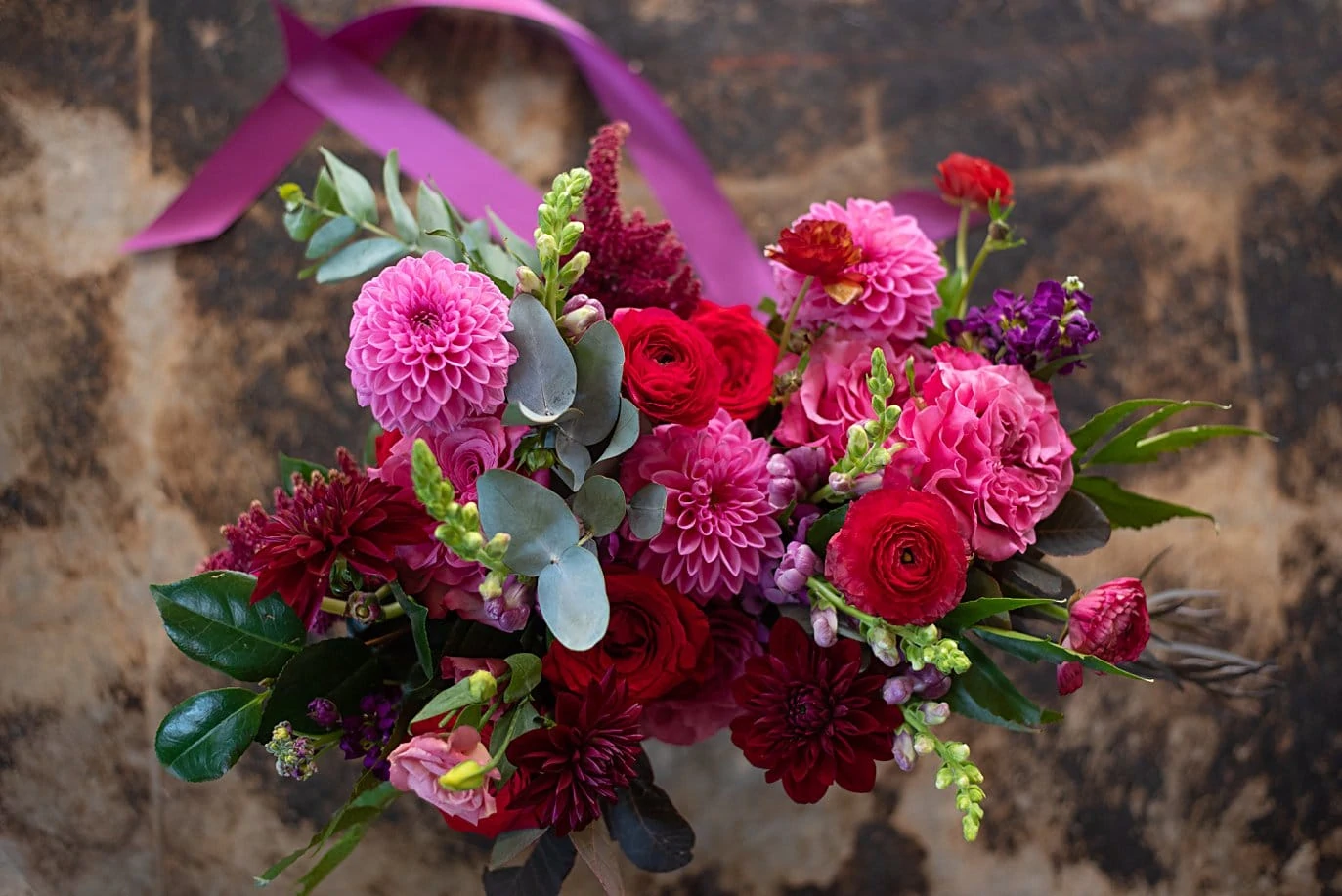 lush and colorful wedding bouquet with pinks, reds, and greens