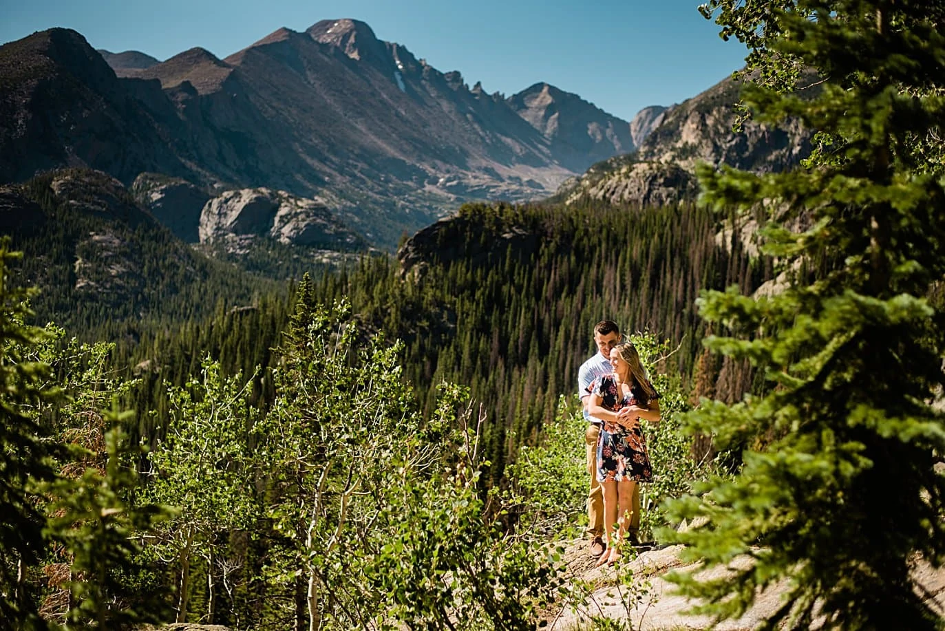 engaged couple hiking to dream lake engagement by Denver wedding photographer Jennie Crate