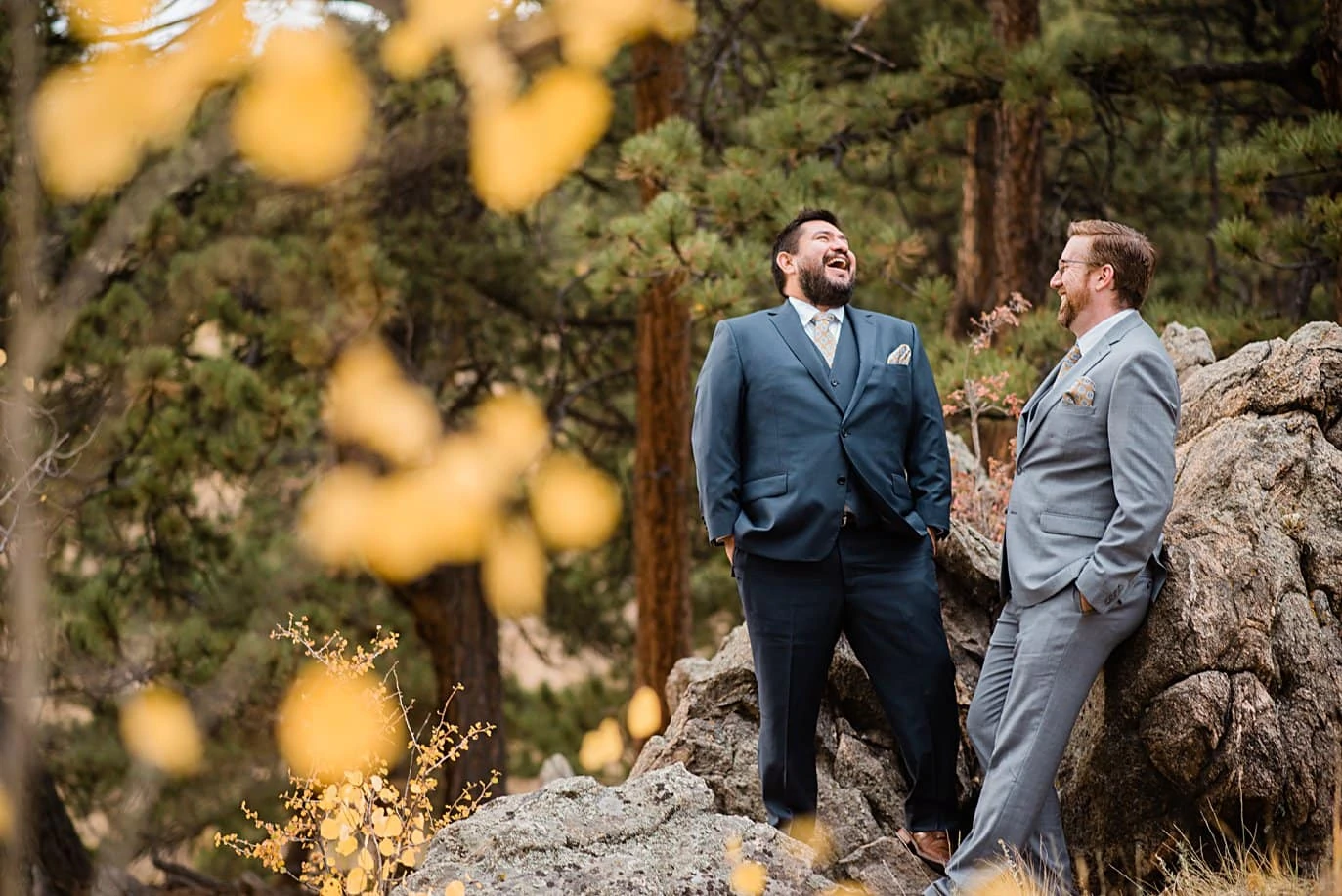 grooms laugh on rocks in Golden Gate Canyon by Colorado gay wedding photographer Jennie Crate