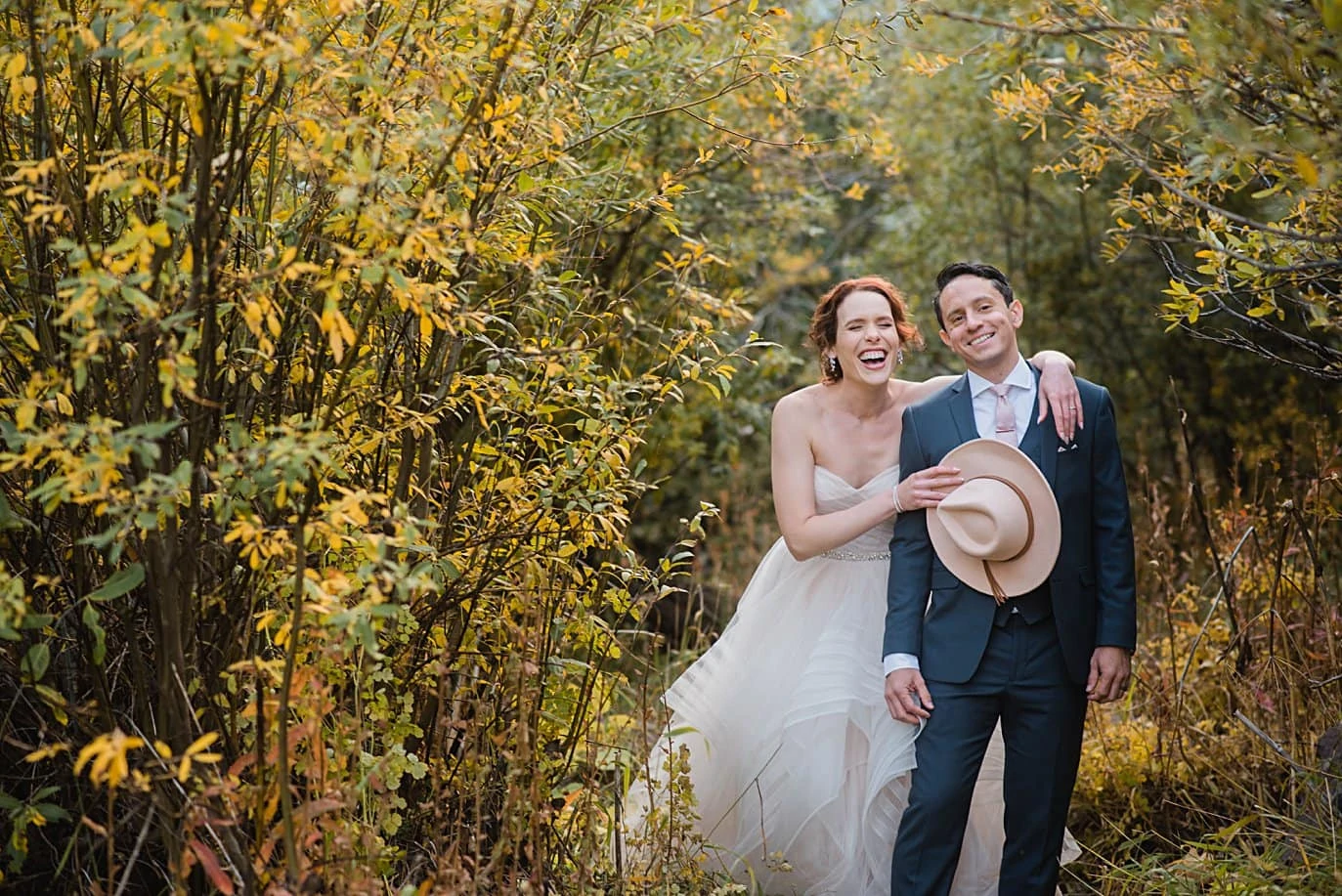 bride with pink hat in fall foliage in Aspen by Denver wedding photographer Jennie Crate