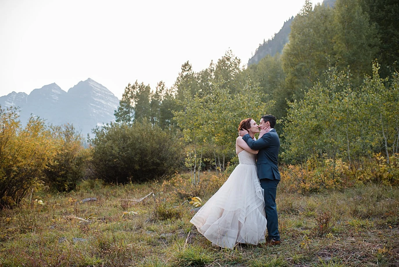 bride and groom kiss in front of Maroon Bells peaks in Aspen by Denver wedding photographer Jennie Crate