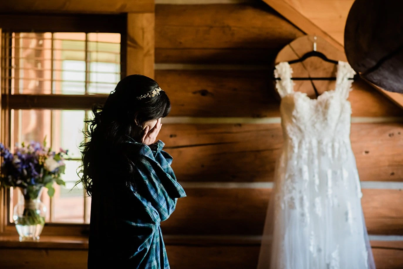 bride overwhelmed with emotion as she looks at wedding dress on wedding day at intimate Grand Lake wedding by Grand Lake wedding photographer Jennie Crate