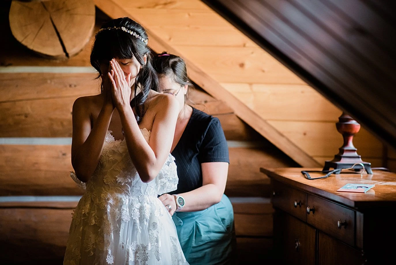 bride overcome with emotion as she gets dressed on wedding day at intimate Grand Lake wedding by Grand Lake wedding photographer Jennie Crate