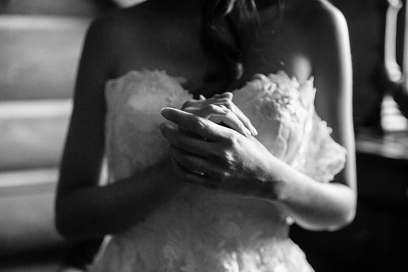 bride clutches hands as she gets laced into wedding dresses at intimate Grand Lake wedding by Grand Lake wedding photographer Jennie Crate