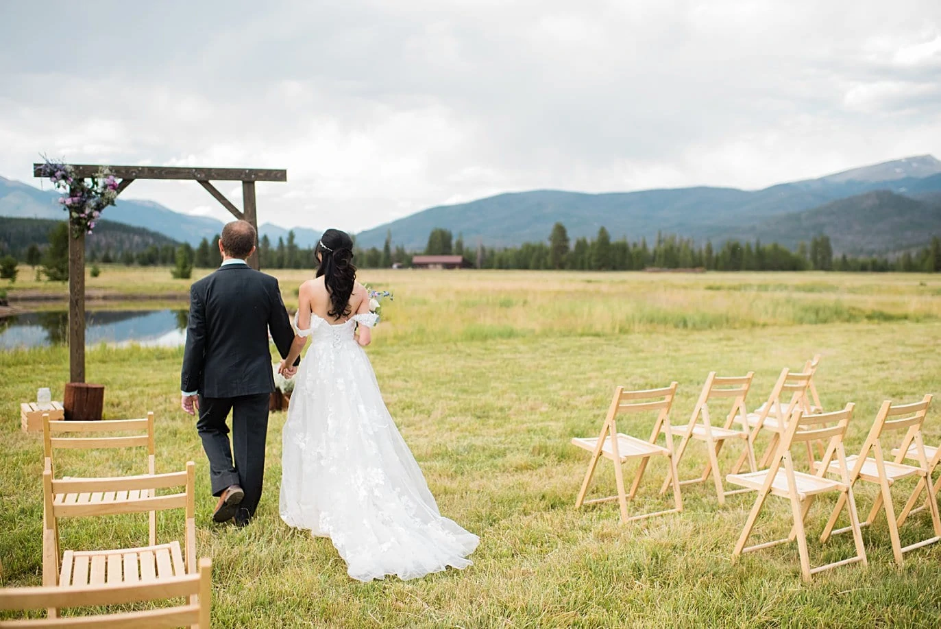 bride and groom approach ceremony at intimate Grand Lake wedding by Denver wedding photographer Jennie Crate