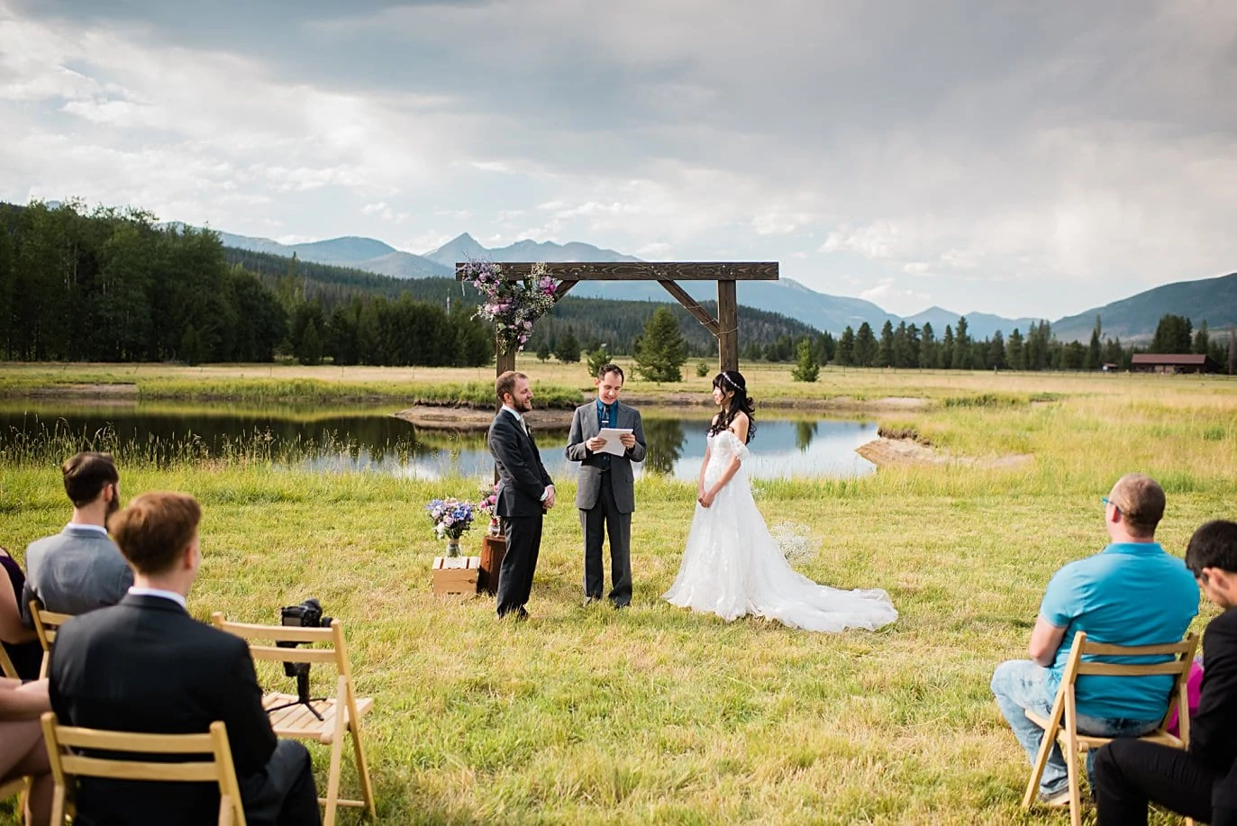 wedding ceremony in meadow with Colorado Mountain view at intimate Grand Lake wedding by Denver wedding photographer Jennie Crate