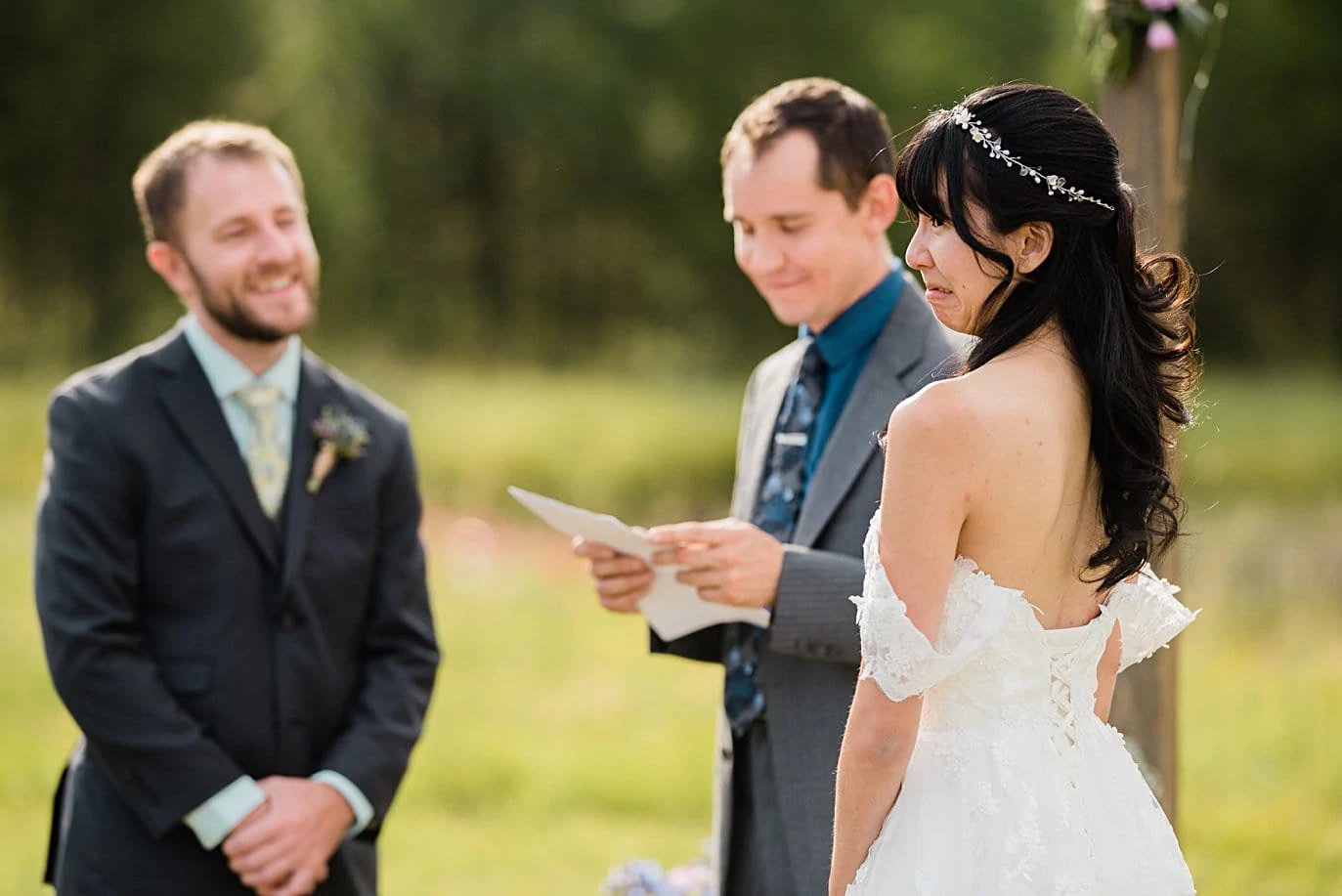 bride and groom share jokes during wedding ceremony at intimate Grand Lake wedding by Denver wedding photographer Jennie Crate