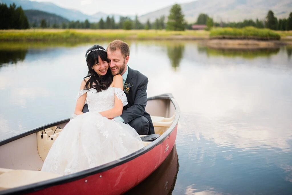 bride and groom in canoe after Colorado wedding ceremony at intimate Grand Lake wedding by Boulder wedding photographer Jennie Crate