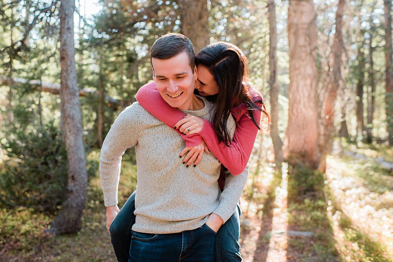 bride on grooms back Mitchell Lake engagement session by Boulder engagement photographer Jennie Crate