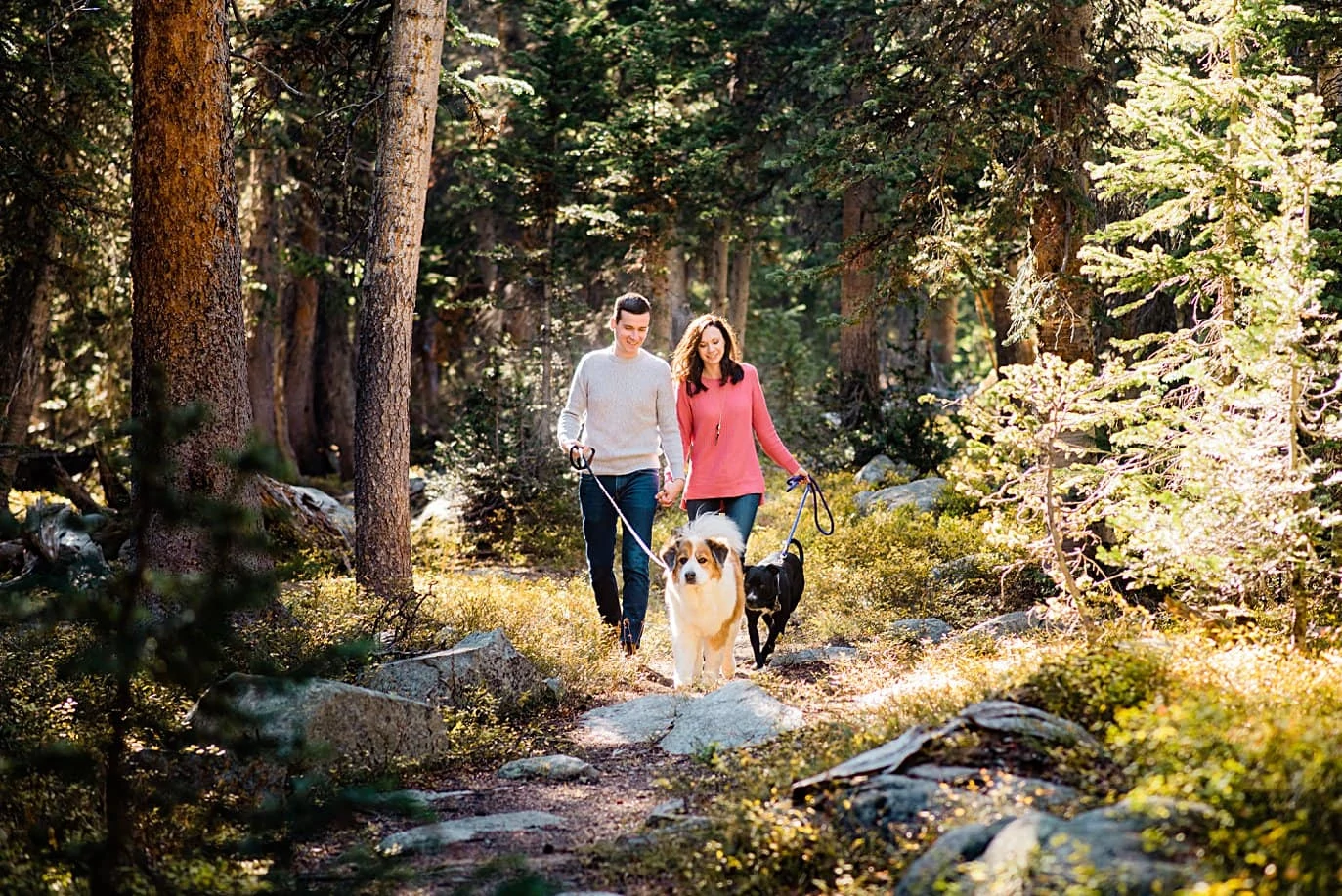 couple walks through woods on hike Mitchell Lake engagement session by Boulder engagement photographer Jennie Crate