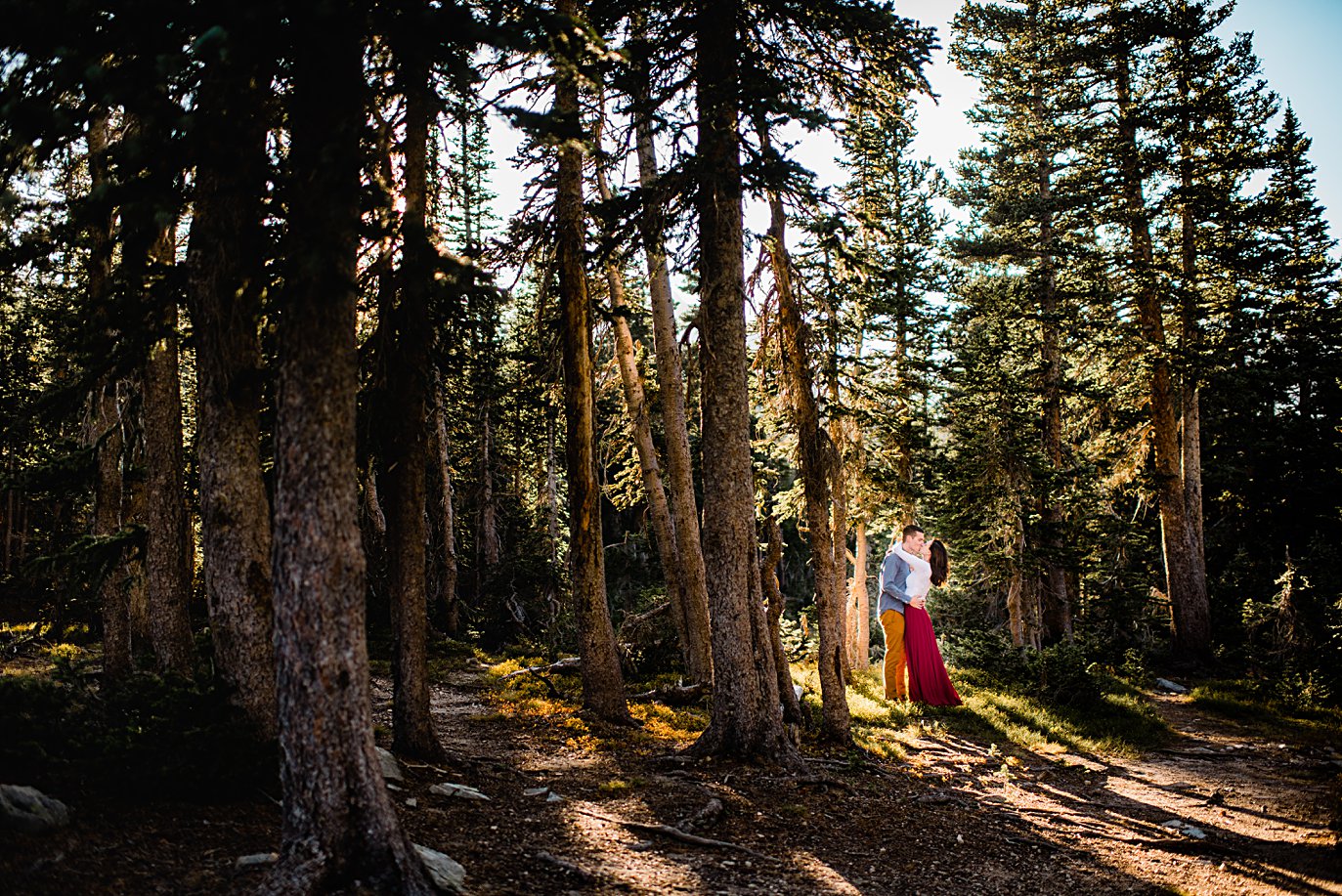 engaged couple in woods engagement hike to Mitchell Lake by Denver engagement photographer Jennie Crate