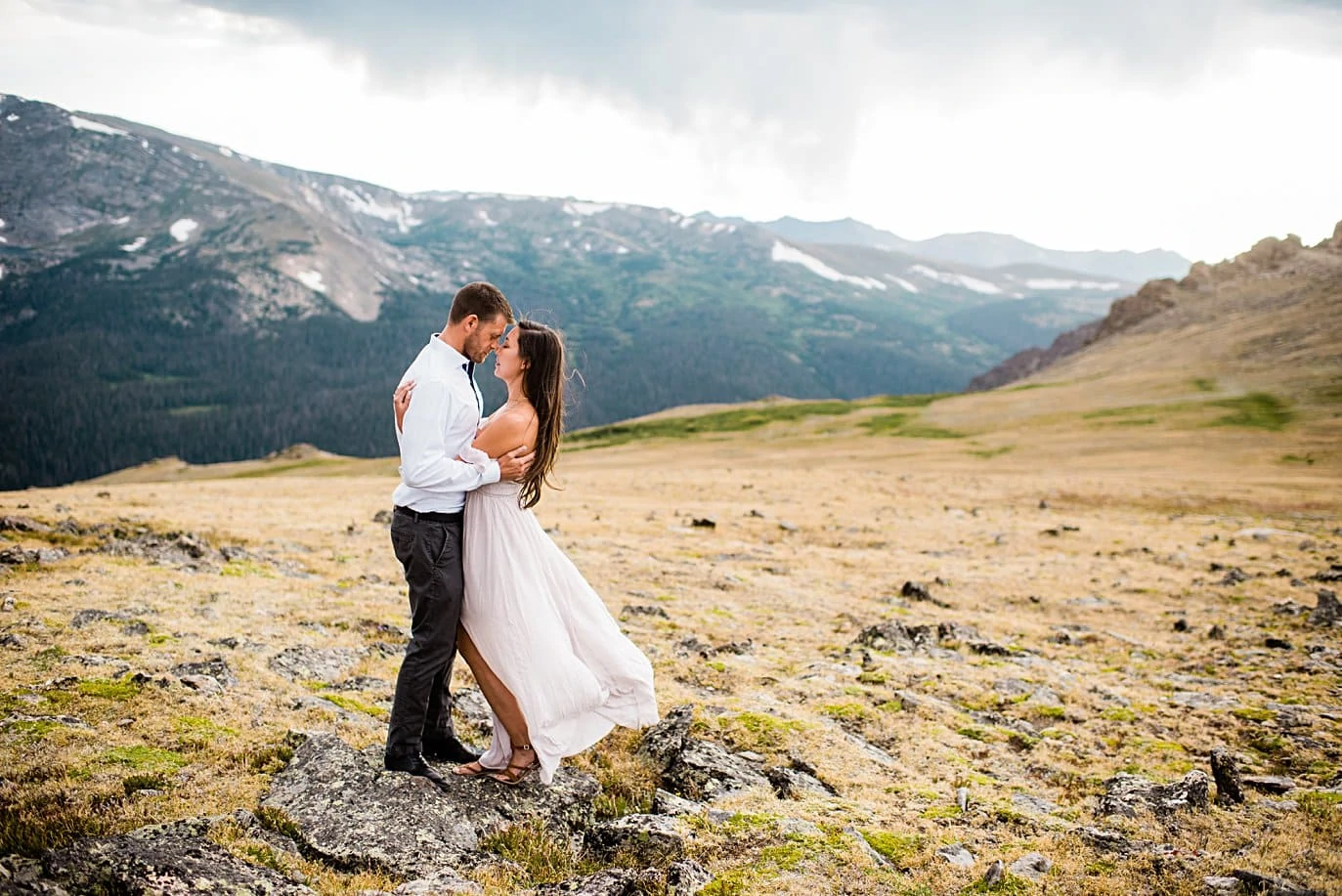 couple perched on rock summer trail ridge road engagement session by RMNP engagement photographer Jennie Crate
