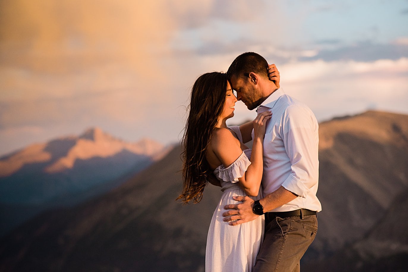 intimate sunset portrait with Longs Peak alpenglow at top of trail ridge road during engagement session by Estes Park engagement photographer Jennie Crate