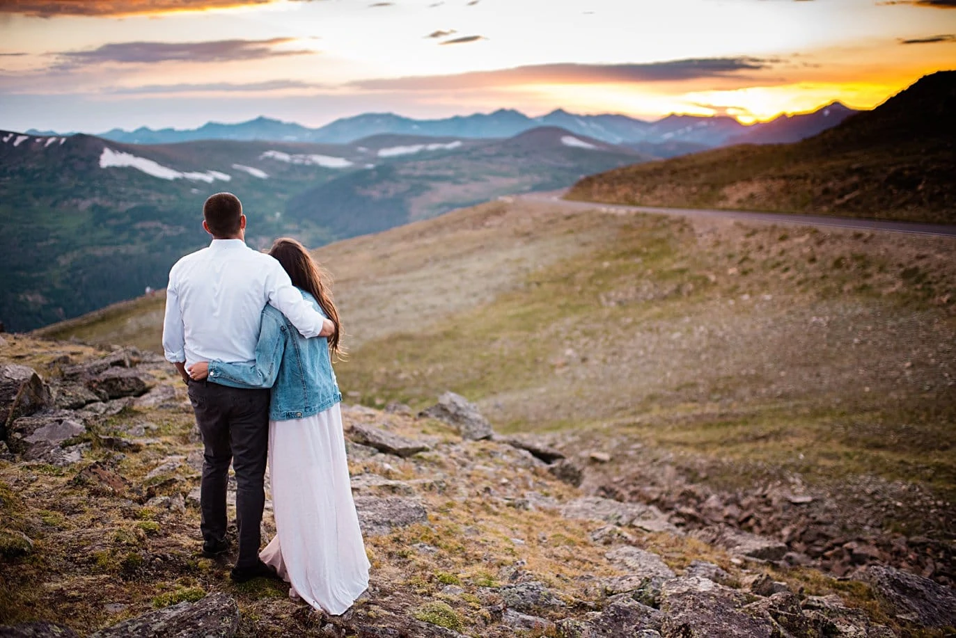 engaged couple take in sunset at top of trail ridge road during engagement session by Estes Park engagement photographer Jennie Crate