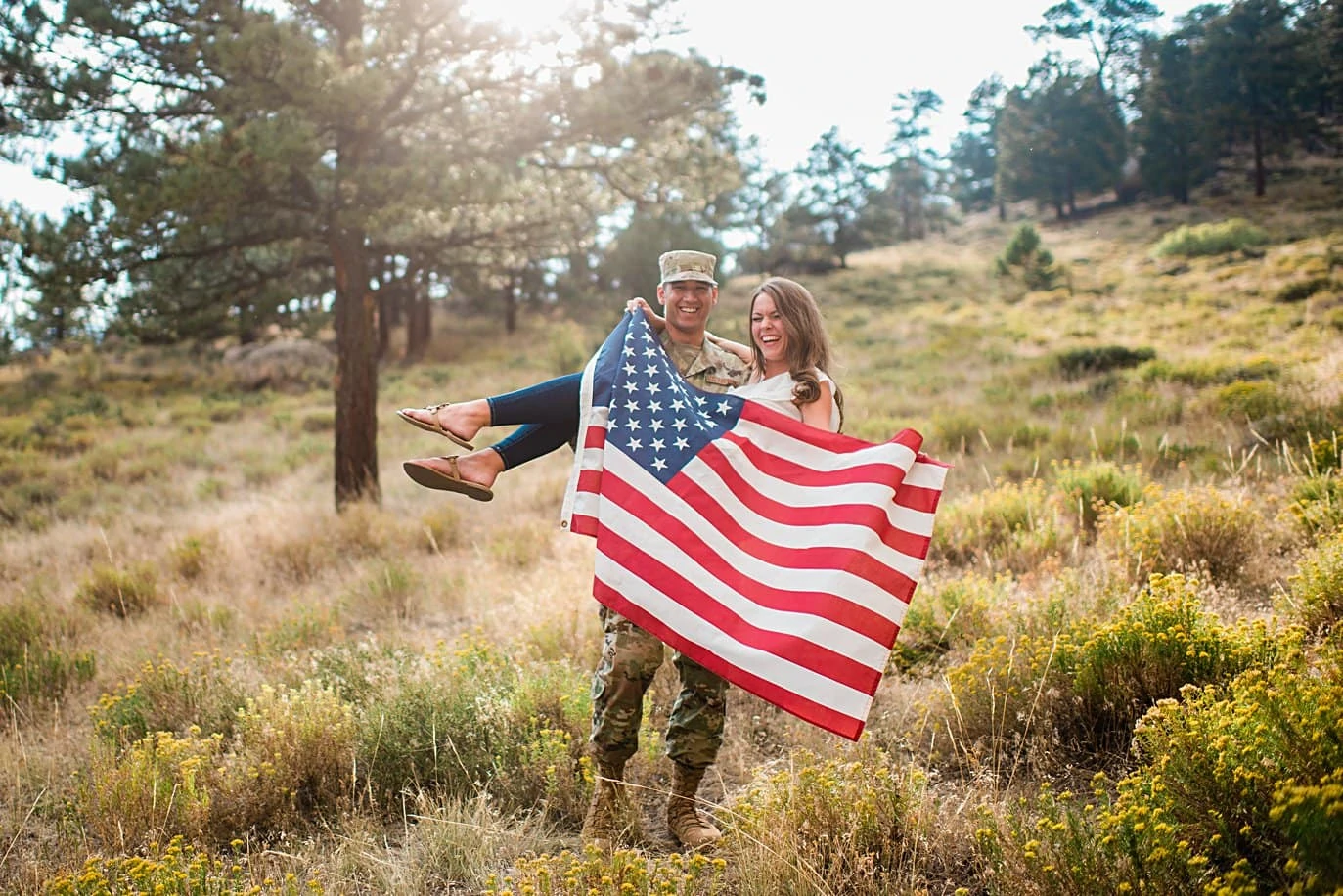 engaged couple with military uniform and American flag at Rocky Mountain National Park engagement by Estes Park engagement photographer Jennie Crate