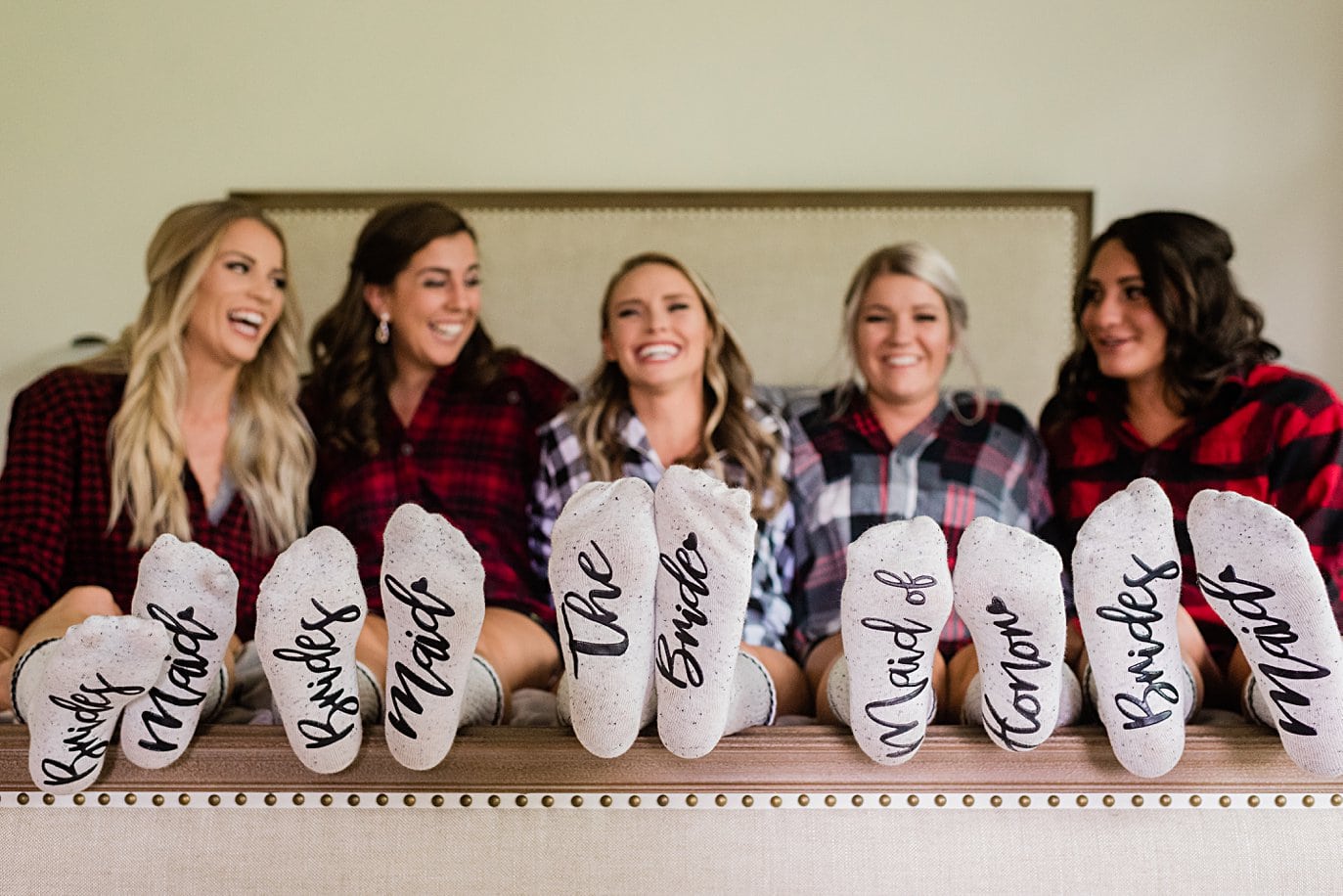 bride and bridesmaids in flannel shirts and matching socks at Larkspur Vail Wedding by Vail Wedding photographer Jennie Crate