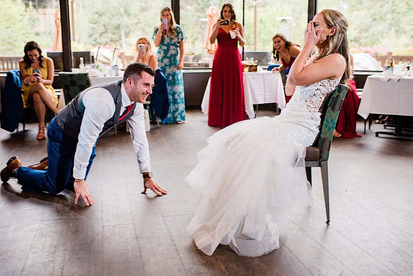 groom approaches bride for garter toss at Vail Manor Lodge wedding by Aspen wedding photographer Jennie Crate