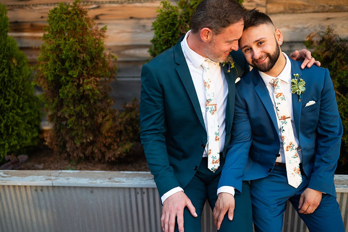 grooms cuddle during sunset at denver gay wedding