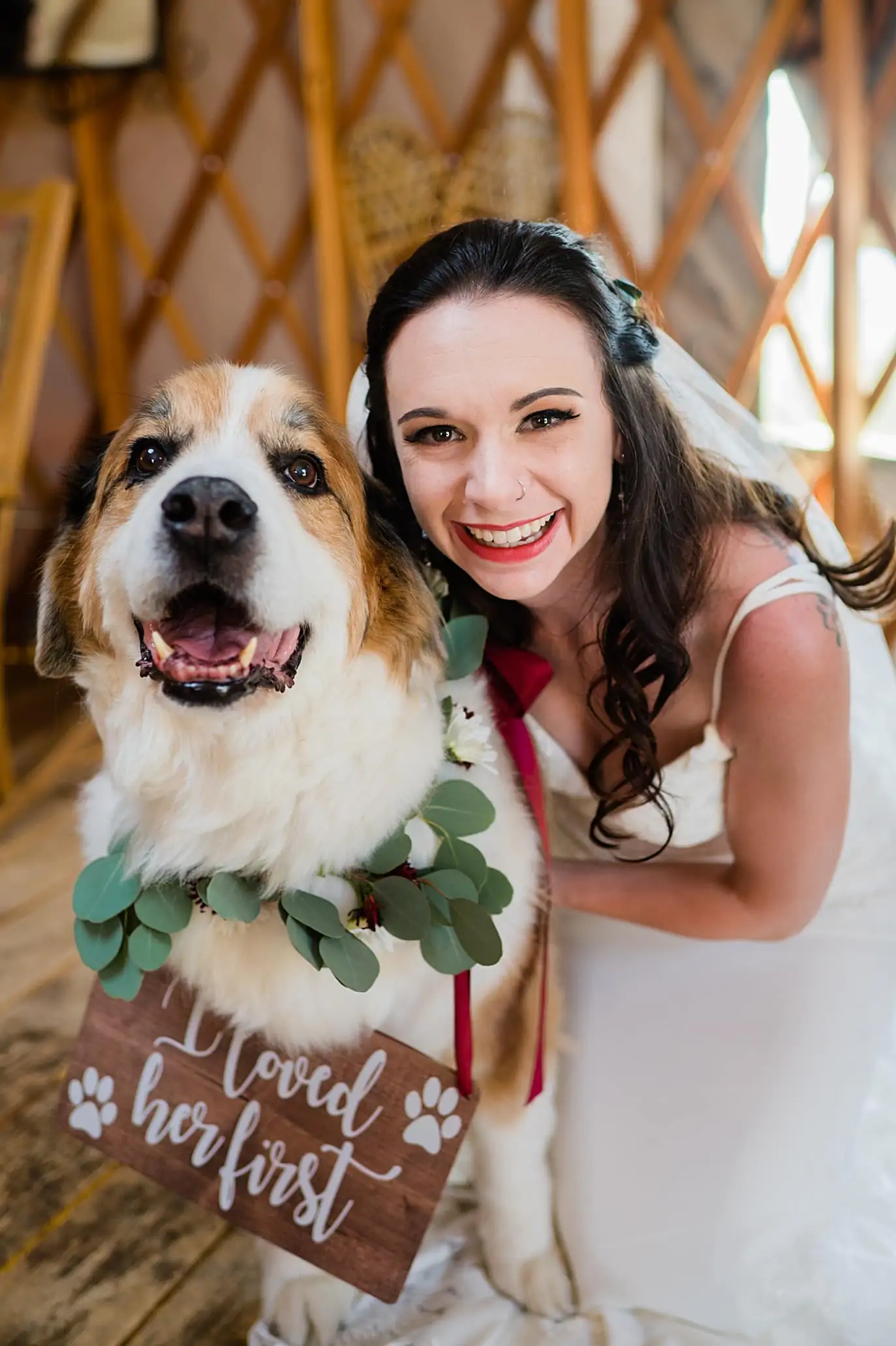 bride cuddles with her dog with a cute wedding sign