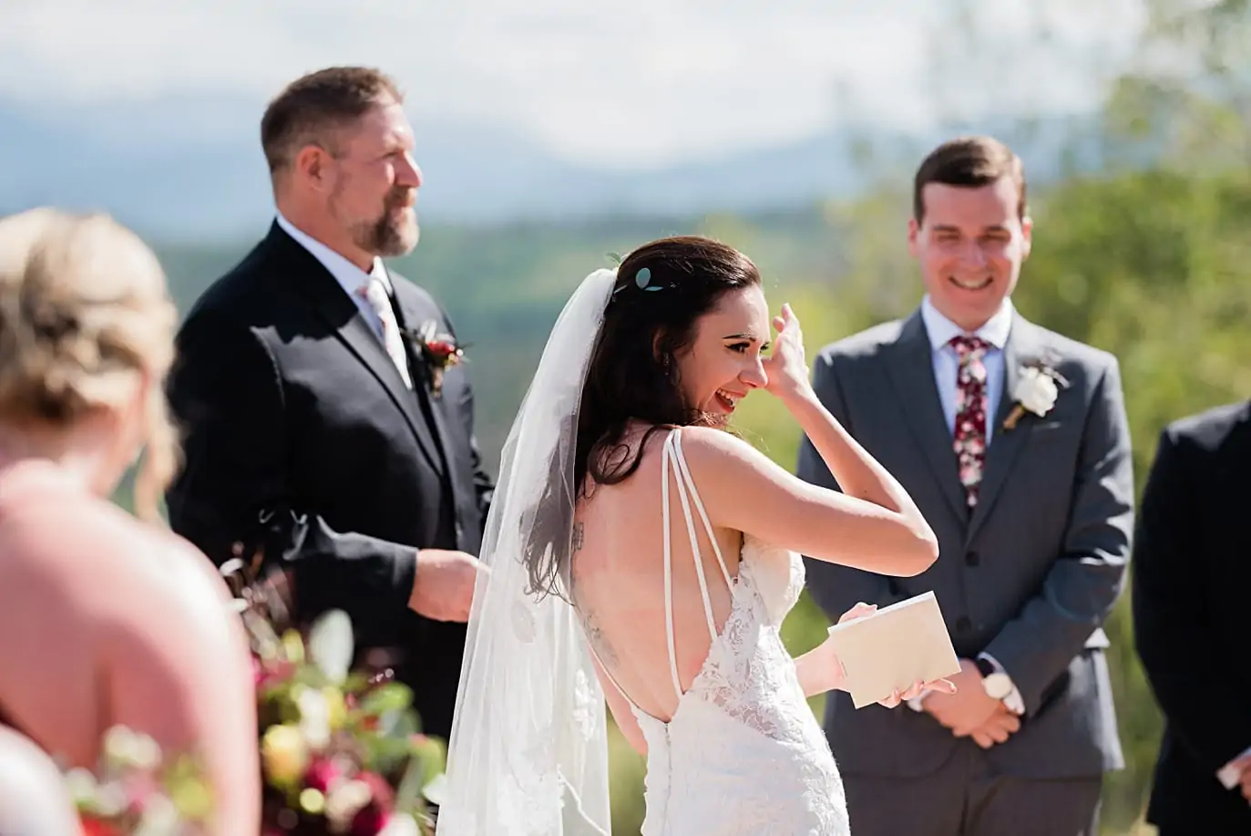 bride wipes tears from her face during her vows at their mountaintop granby wedding ceremony