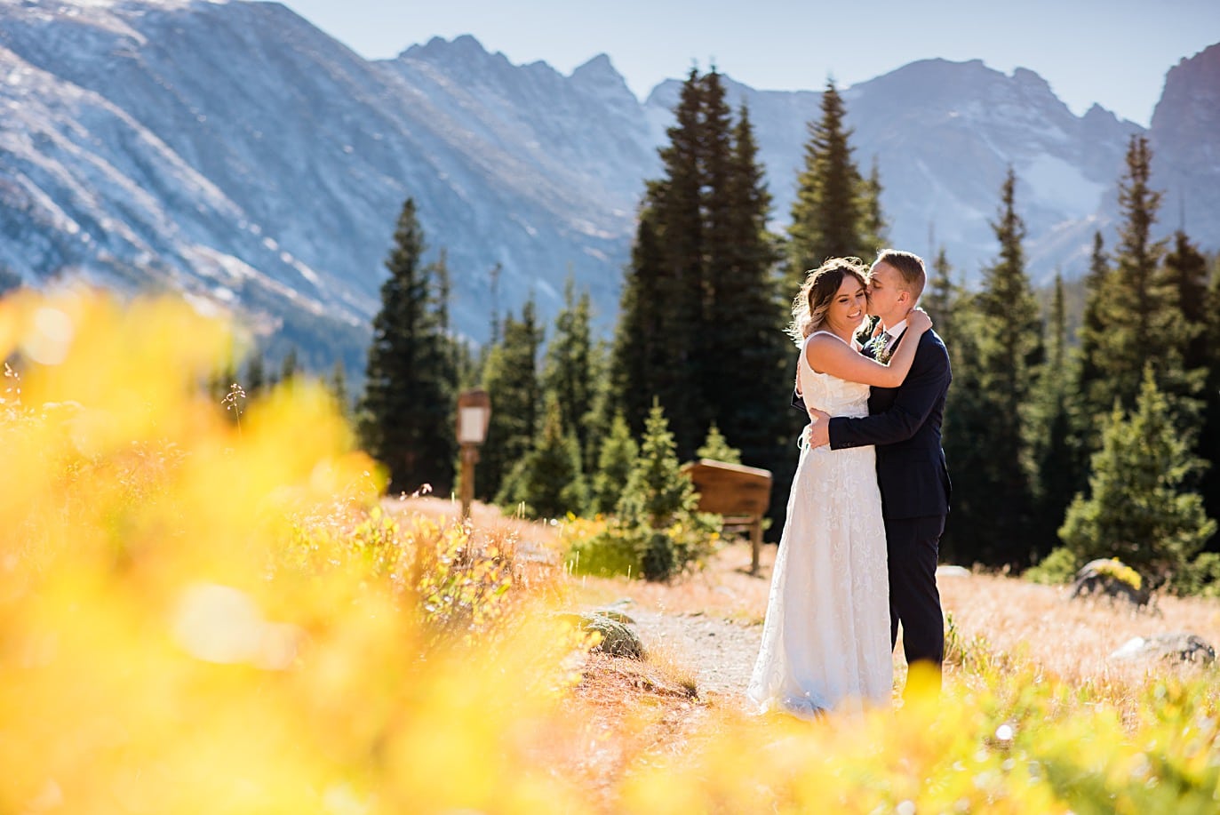 bride and groom cuddle with yellow fall colors before their elopemenet at Long Lake