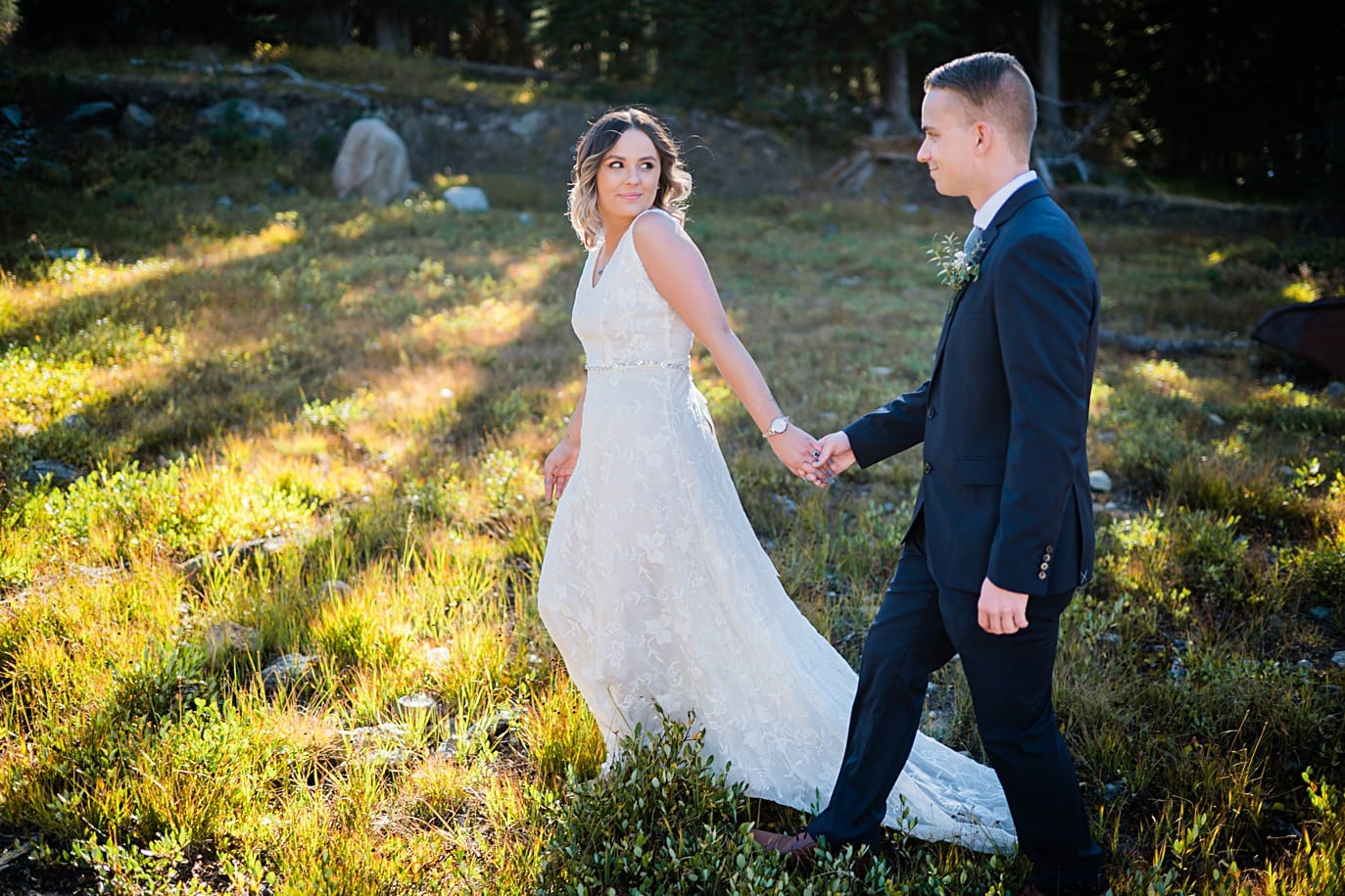 couple walks in sunlight during their long lake elopement in Colorado