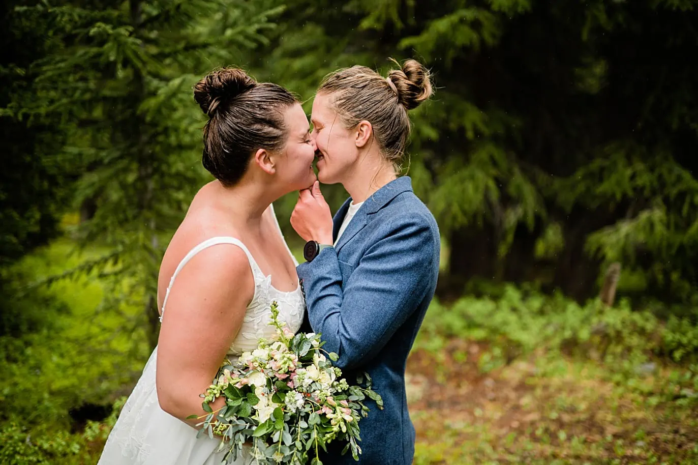 two brides with rainswept buns share a kiss after reading vows on Breckenridge Adventure session