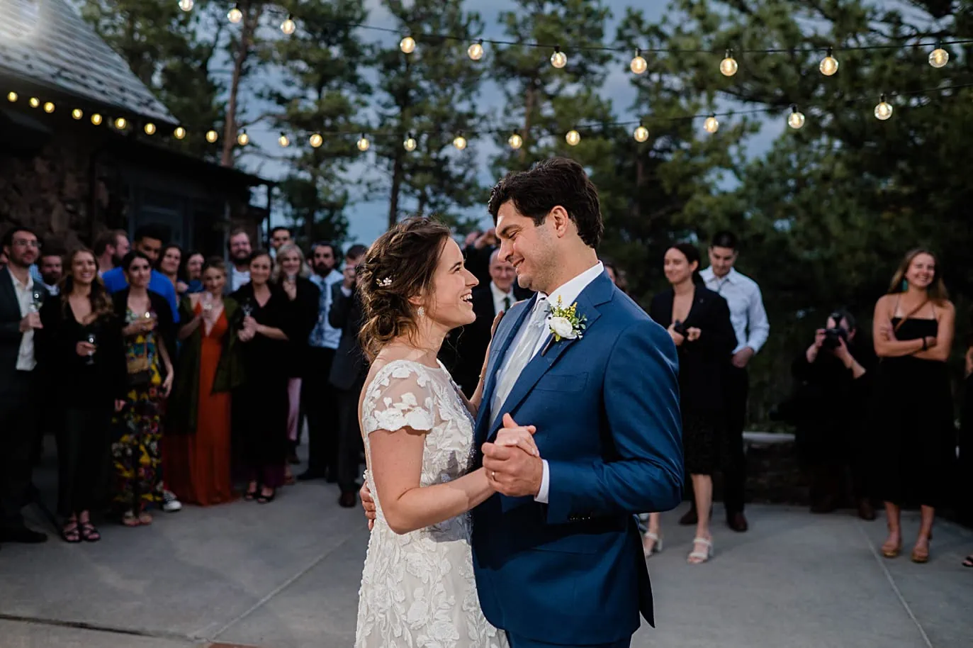 Bride and groom first dance under the market lights on the patio at their Boettcher Mansion wedding