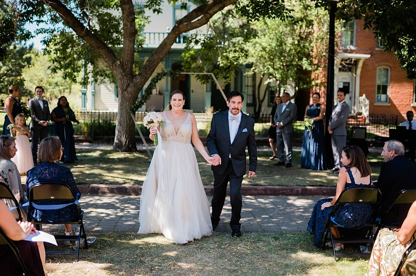 Bride and groom walk back down aisle after their wedding ceremony at 9th street park at Auraria Campus