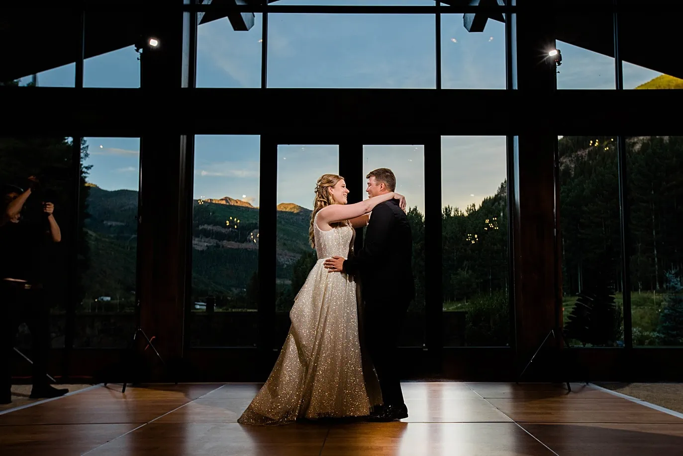 Bride and groom share their first dance at their Vail Golf Club wedding with the alpenglow in the background